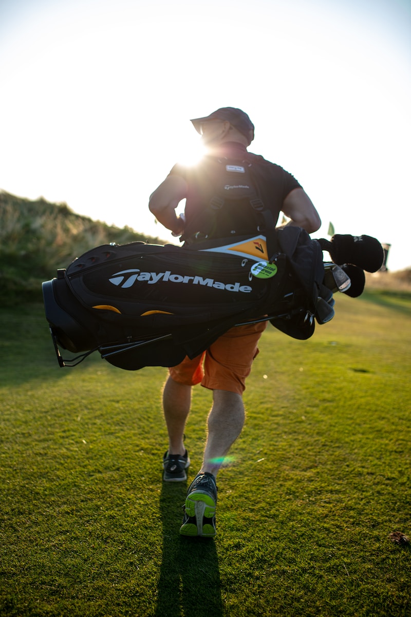 Un homme portant un sac d'équipement de golf." Les différents types de sac de golf