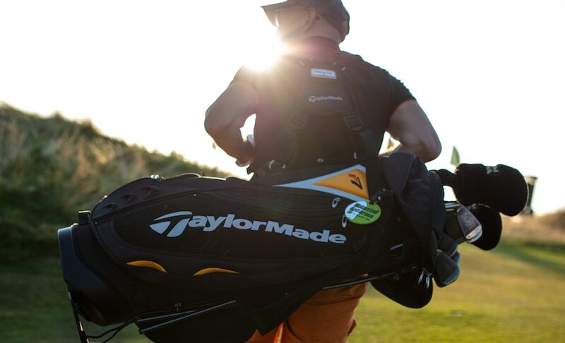 Un homme portant un sac d'équipement de golf." Les différents types de sac de golf